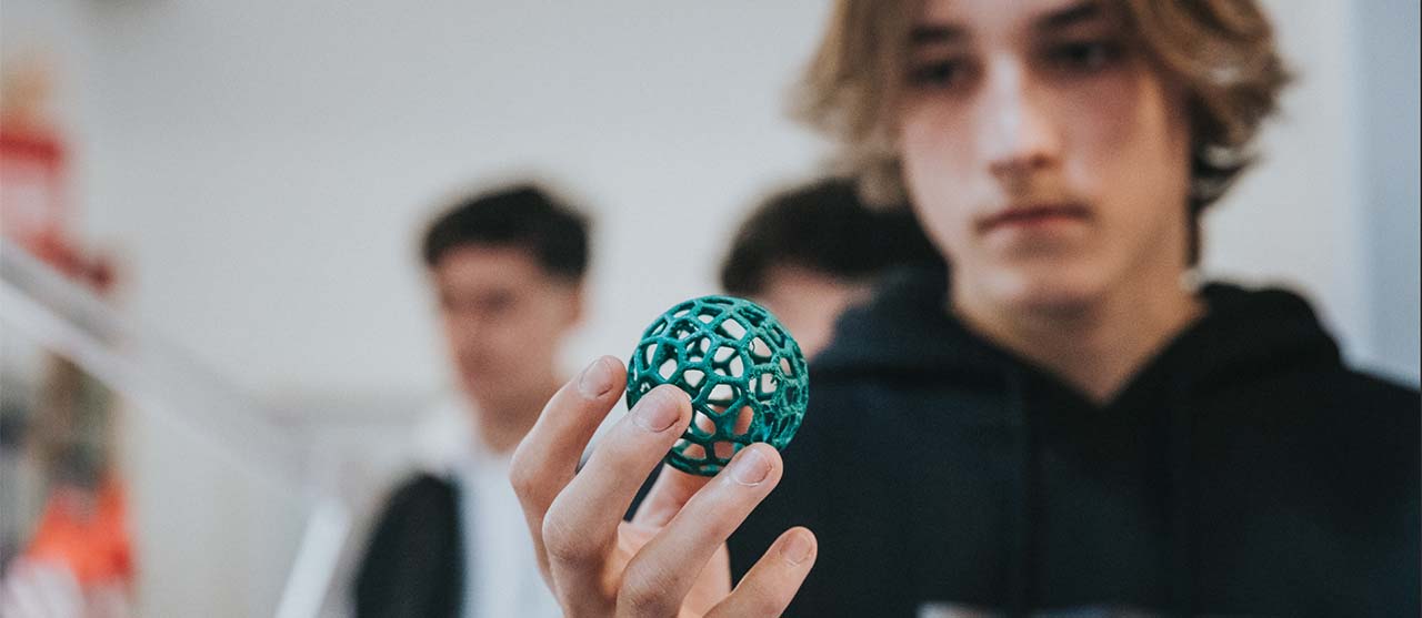 Een student uit de bachelor ergotherapie van HOGENT bestudeert een grijpbal.