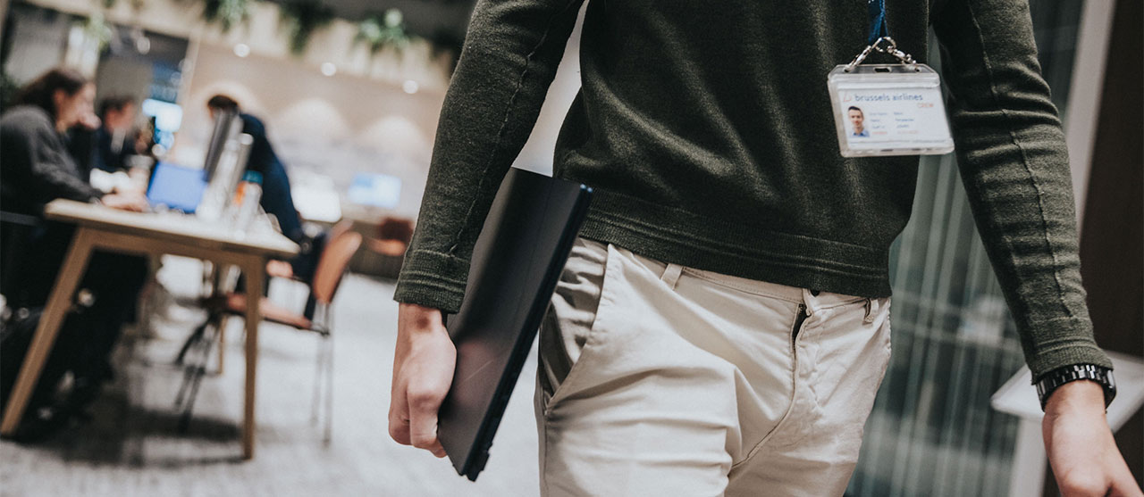 student systeem- en netwerkbeheer wandelt met laptop in de hand naar zijn werkplek op stage