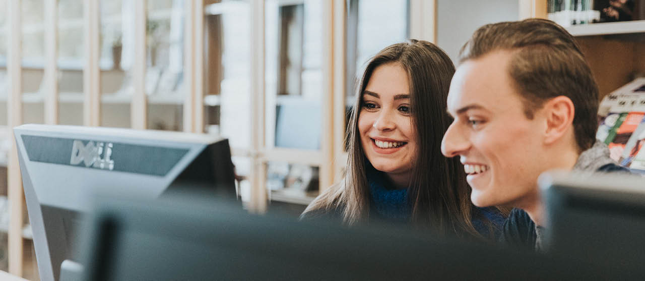 Twee studenten uit het graduaat Accounting Administration van HOGENT kijken samen naar een computerscherm.