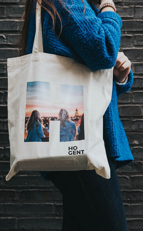 Stagestudente uit de opleiding dierenzorg poseert met een totebag van HOGENT.