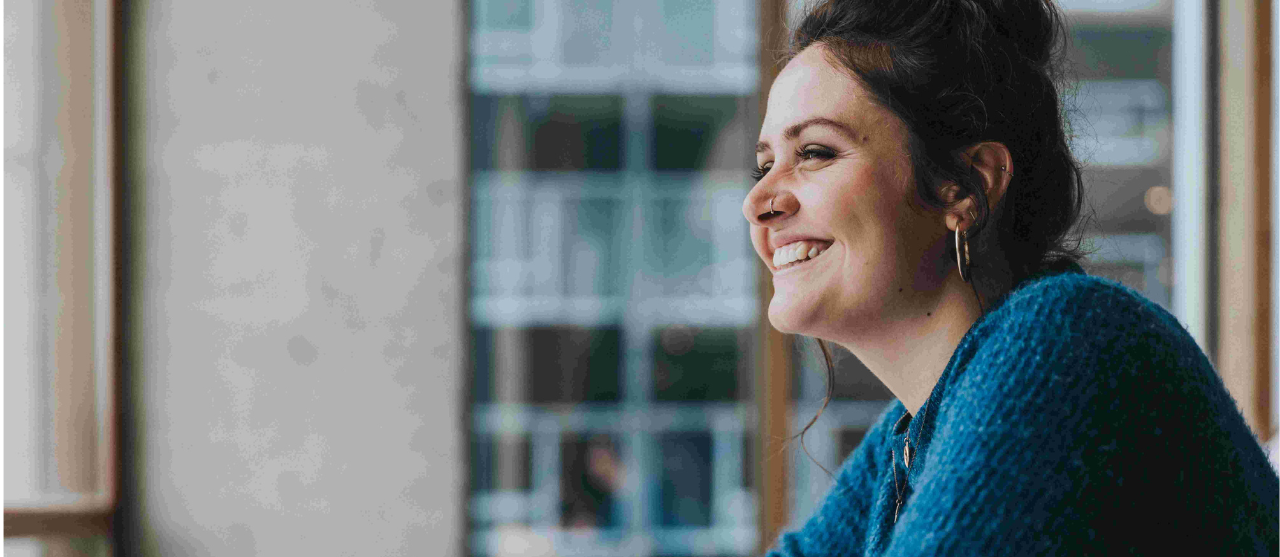 Een studente uit de afstudeerrichting financiën en verzekeringen van de bachelor bedrijfsmanagement aan HOGENT praat met een medestudent op de campus.