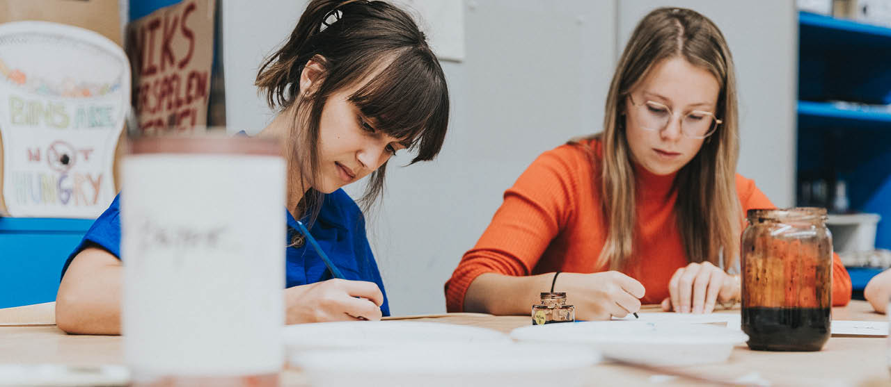 Twee studenten orthopedagogie van HOGENT aan de slag met inkt en papier.