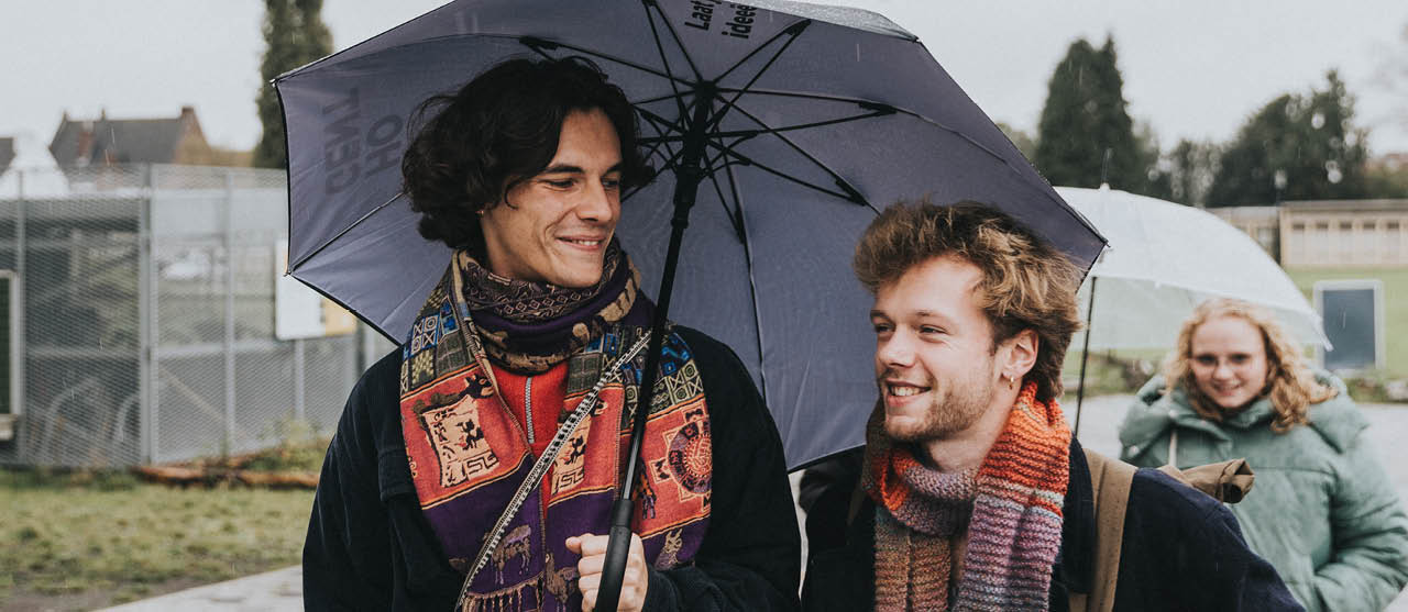 Twee studenten orthopedagogie van HOGENT in gesprek onder een paraplu.