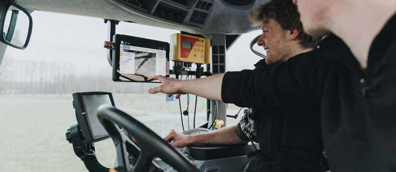 Twee landbouwstudenten van HOGENT besturen een tractor met GPS-systeem.