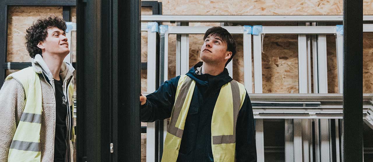 Twee studenten uit de opleiding werforganisatie aan HOGENT inspecteren bouwmaterialen.