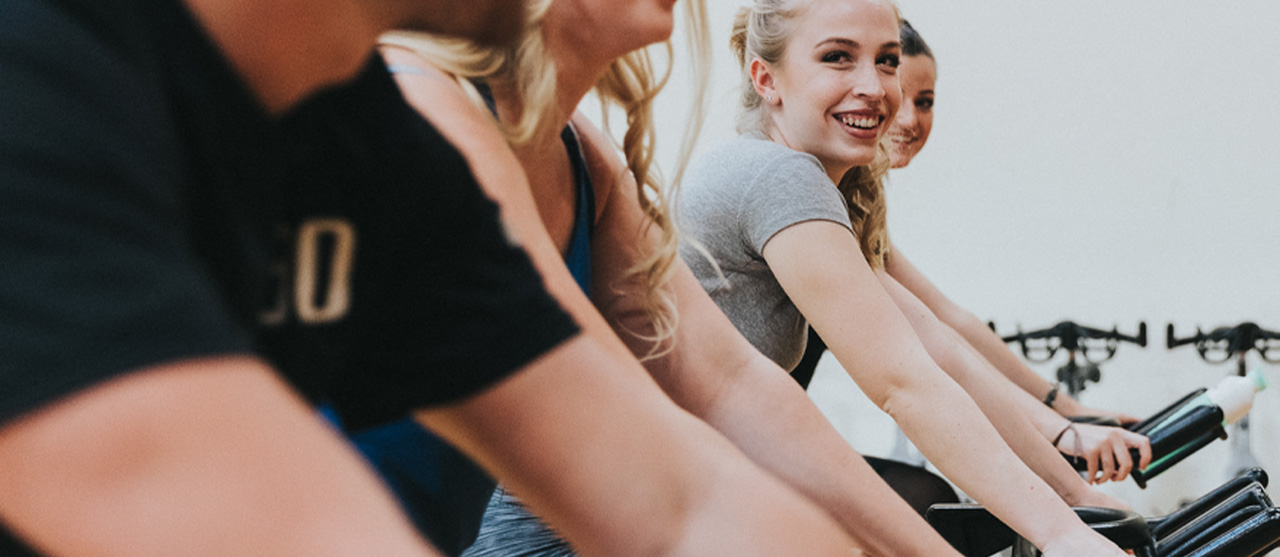 Studenten LO en bewegingsrecreatie tijdens een les spinning in een fitnessclub.