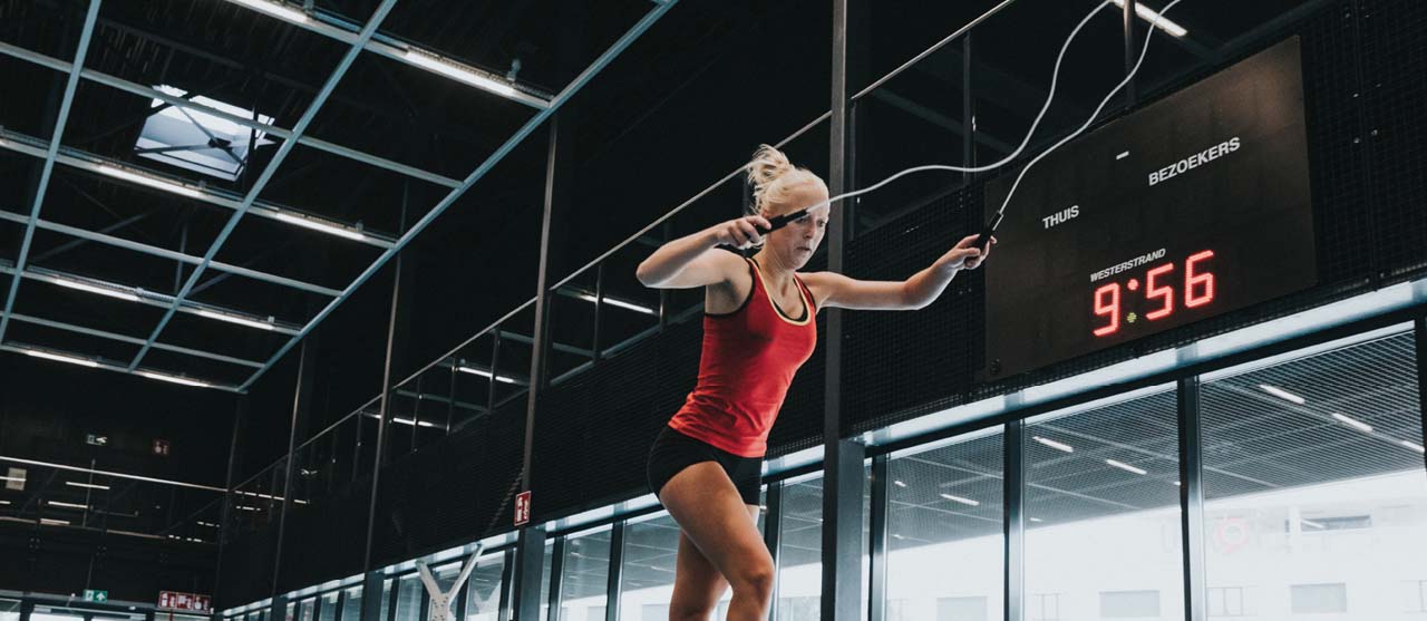 Een studente LO en bewegingsrecreatie springt touw in de sporthal van HOGENT.