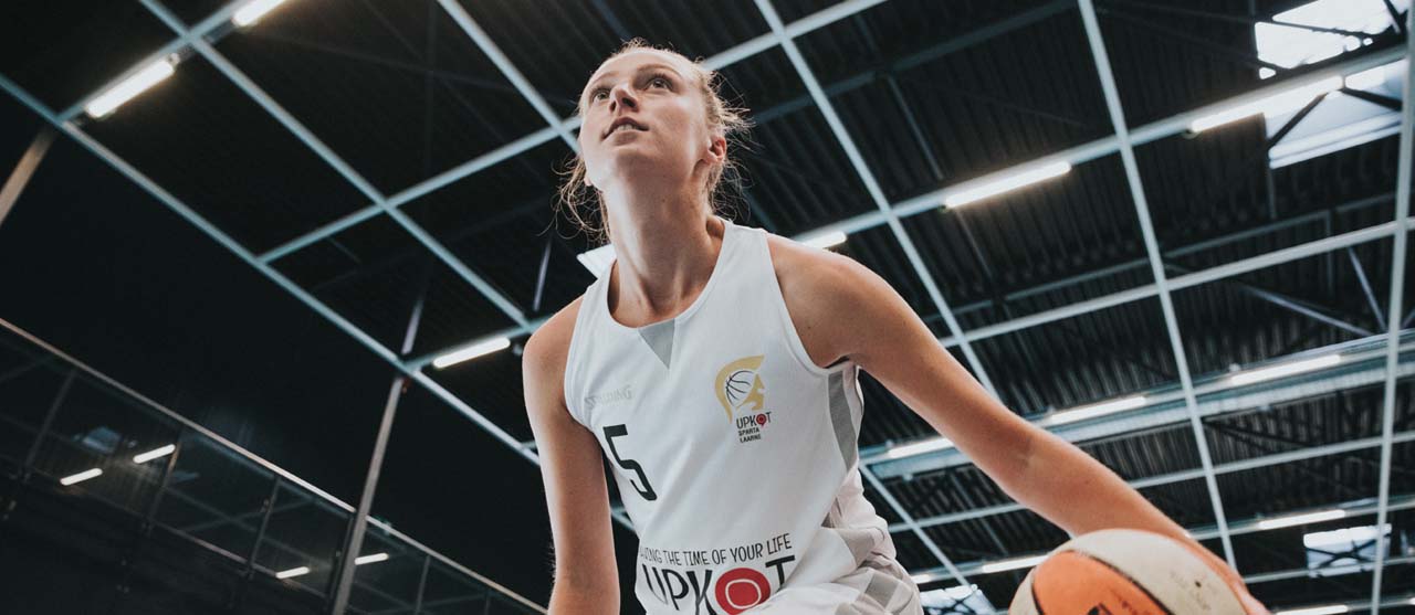 Een studente LO en bewegingsrecreatie tijdens een basketbaltoernooi in de sporthal van HOGENT.