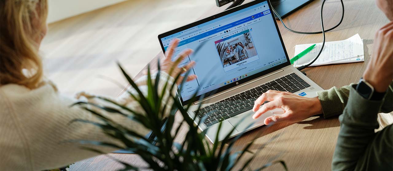 Studenten International Communication bekijken voorstel van communicatiecampagne op hun laptop.