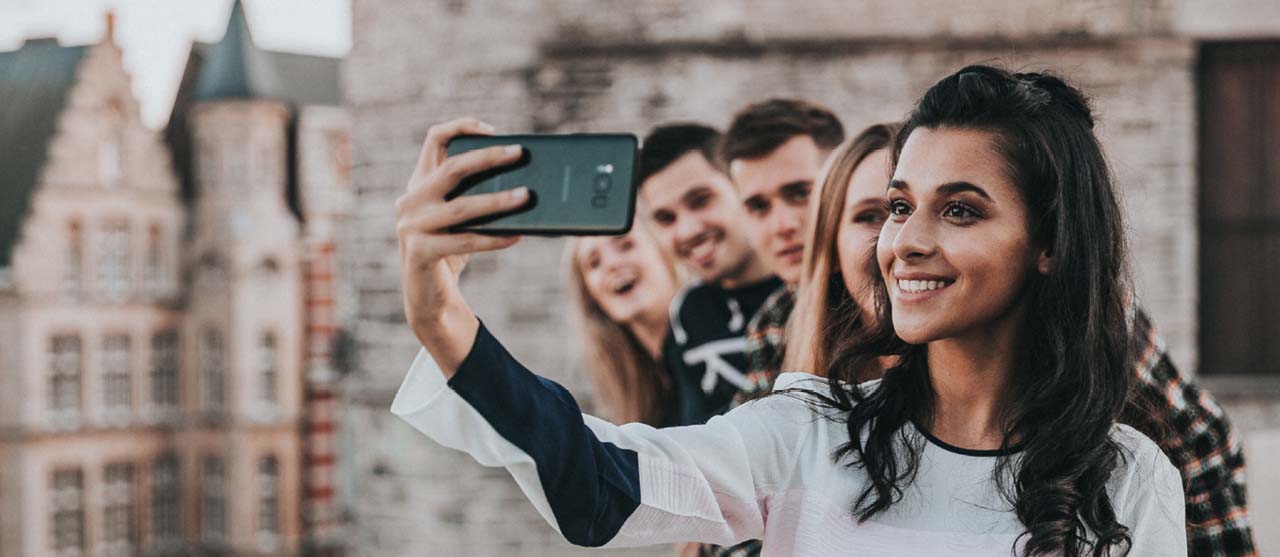 Studente secundair onderwijs neemt een groepsselfie tijdens een uitwisseling in het buitenland.