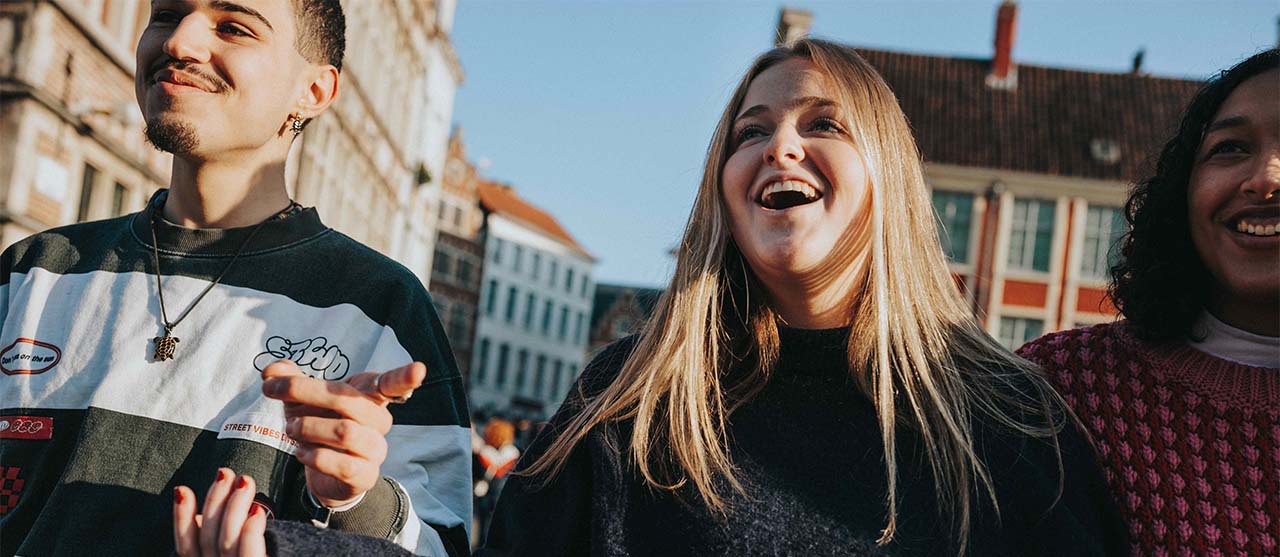 sfeerbeeld van drie lachende studenten in het stadscentrum van Gent