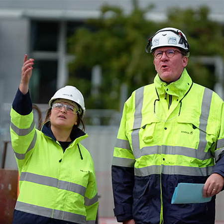 Alumnus landmeten Marie aan het werk als landmeter in overleg met een collega