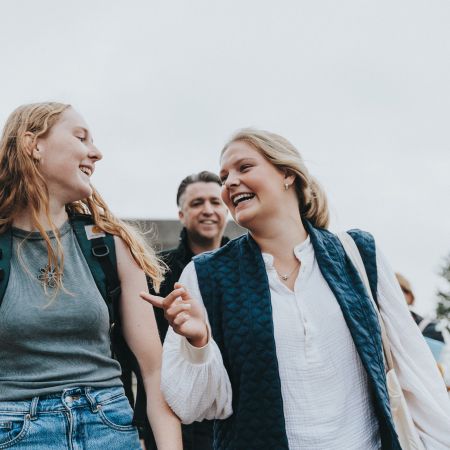 Bijna afgestudeerde kleuterjuf Nelle wandelt al lachend met een groepje studenten over de campus.