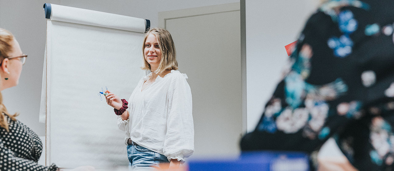 Studenten modetechnologie van HOGENT brainstormen met elkaar aan een flipchart.